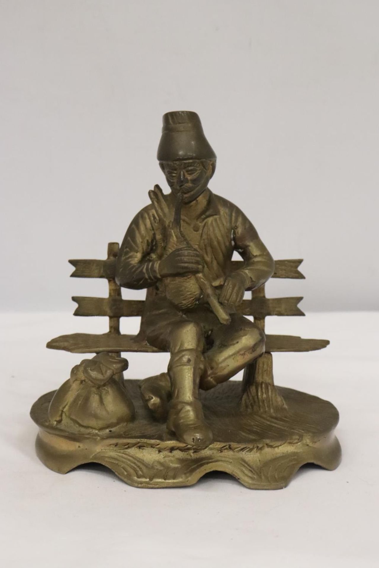 A BRASS SEATED MUSICIAN