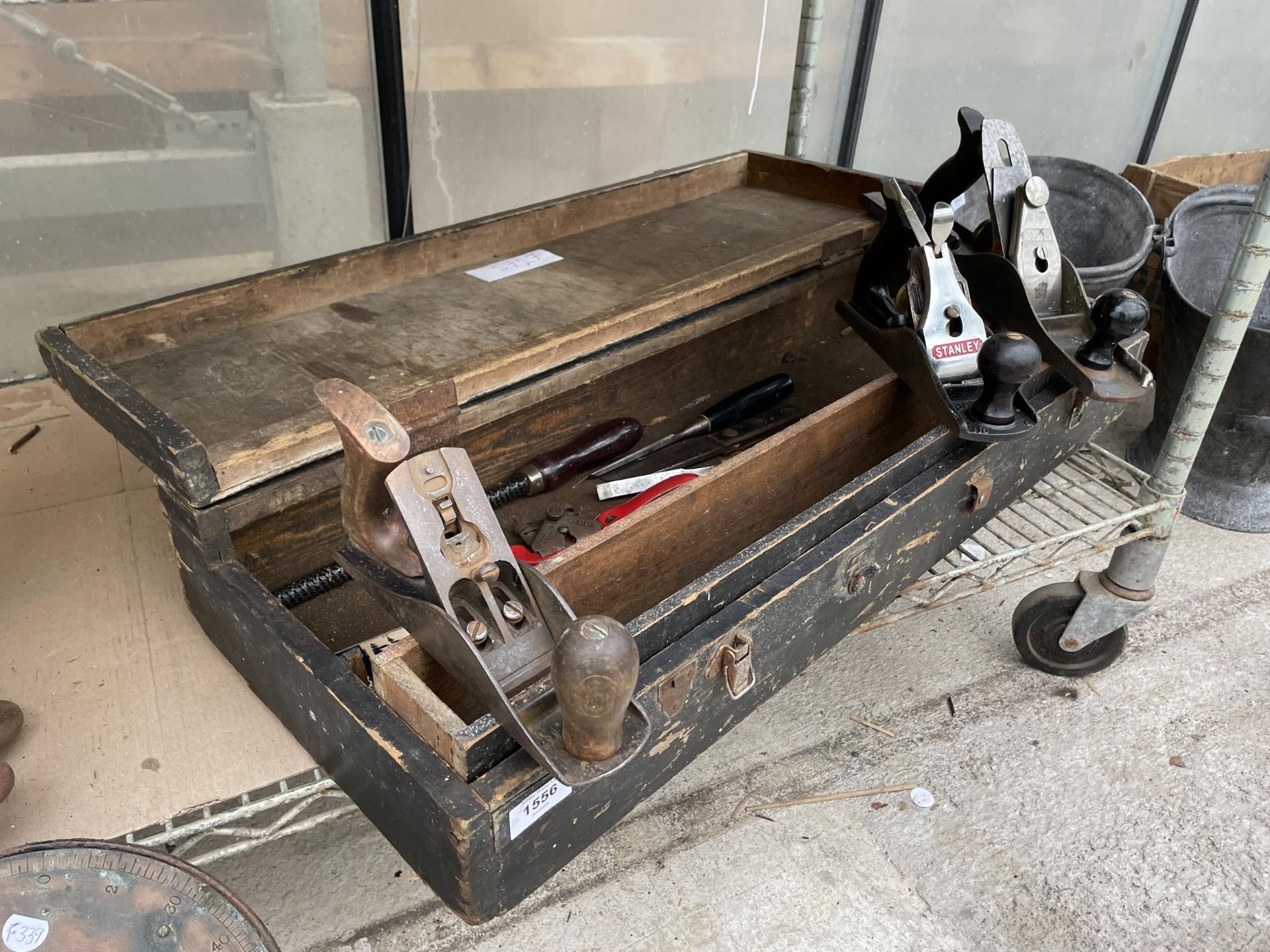 A VINTAGE WOODEN TOOL CHEST WITH AN ASSORTMENT OF TOOLS TO INCLUDE WOOD PLANES AND CHISELS ETC