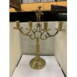 A HEAVY BRASS CANDELABRA WITH A FIGURE HOLDING A STAFF