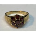 A 9 CARAT GOLD RING WITH GARNETS IN A CLUSTER DESIGN SIZE M