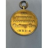 AN 1883/4 F.A. CUP FINAL WINNER'S MEDAL. THIS MEDAL IS TESTED TO 22 CARAT GOLD AND WAS AWARDED TO
