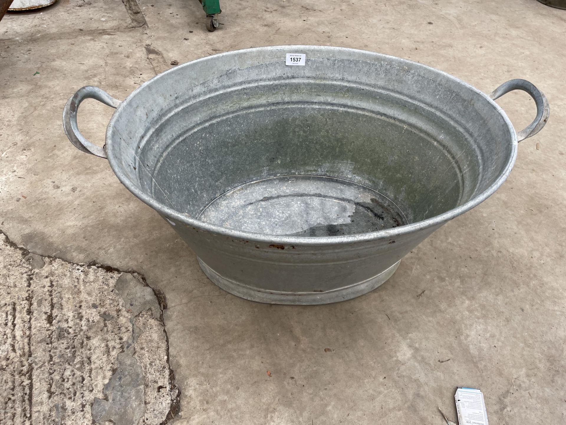 A SMALL OVAL GALVANISED TIN BATH