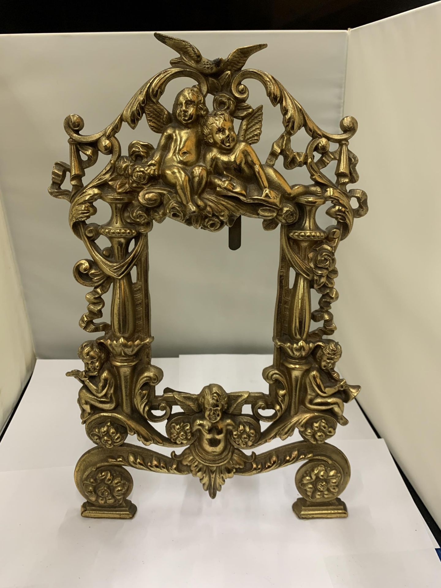 A DECORATIVE HEAVY BRASS FRAME WITH CHERUBS