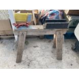 A WOODEN BUILDERS TRESTLE WITH A VICE AND A SAW JIG