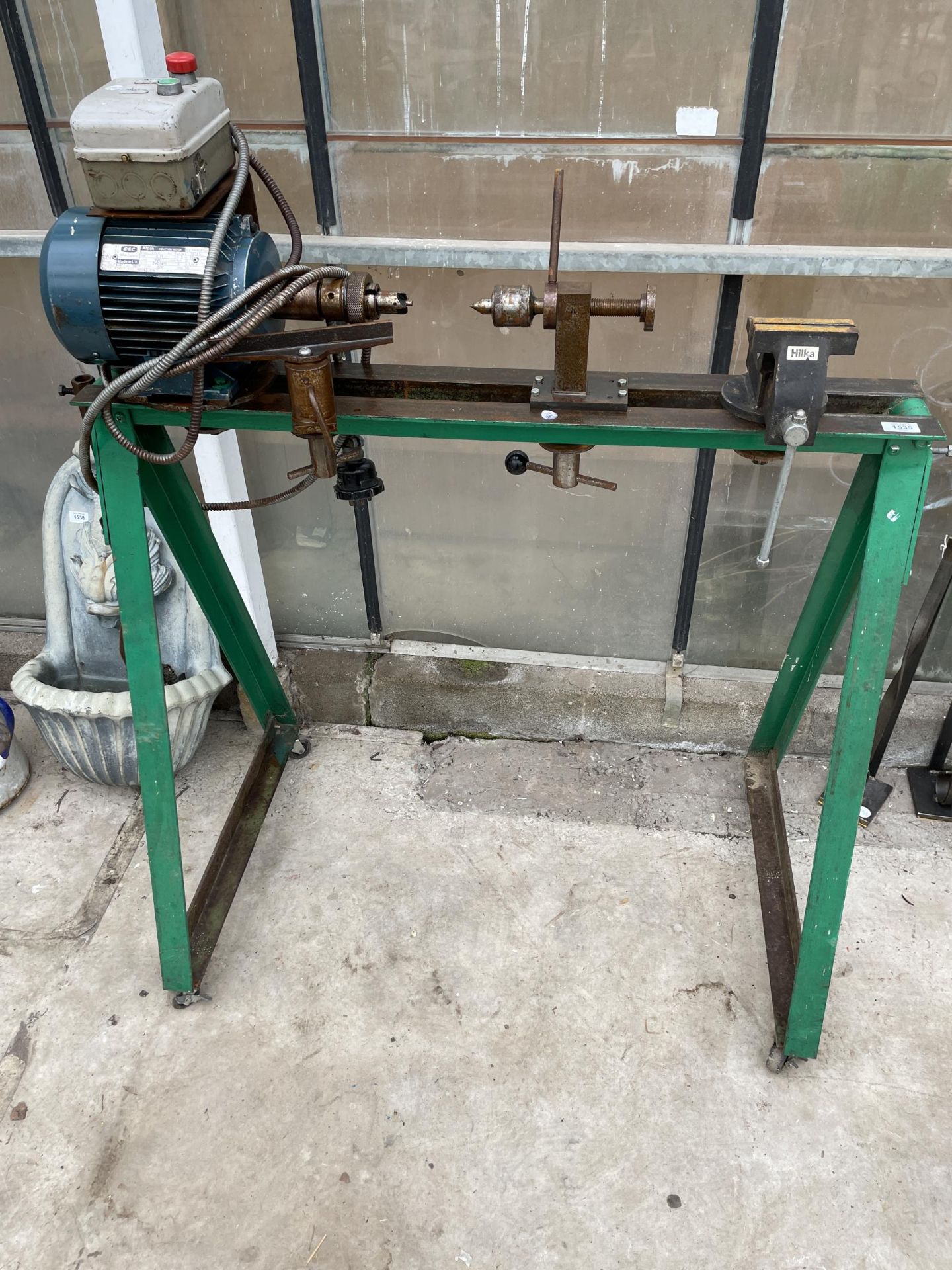 A METAL TURNING LATHE ON A STAND WITH A HILKA BENCH VICE