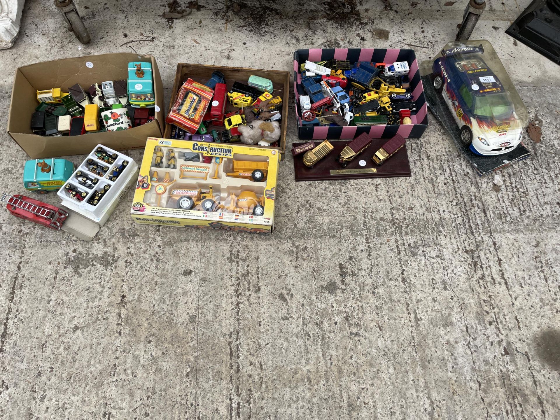 A LARGE ASSORTMENT OF MODEL VEHICLES AND TOYS TO INCLUDE CARS AND TRUCKS ETC