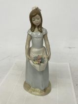 A NADAL FIGURE OF A GIRL CARRYING FLOWERS IN HER APRON