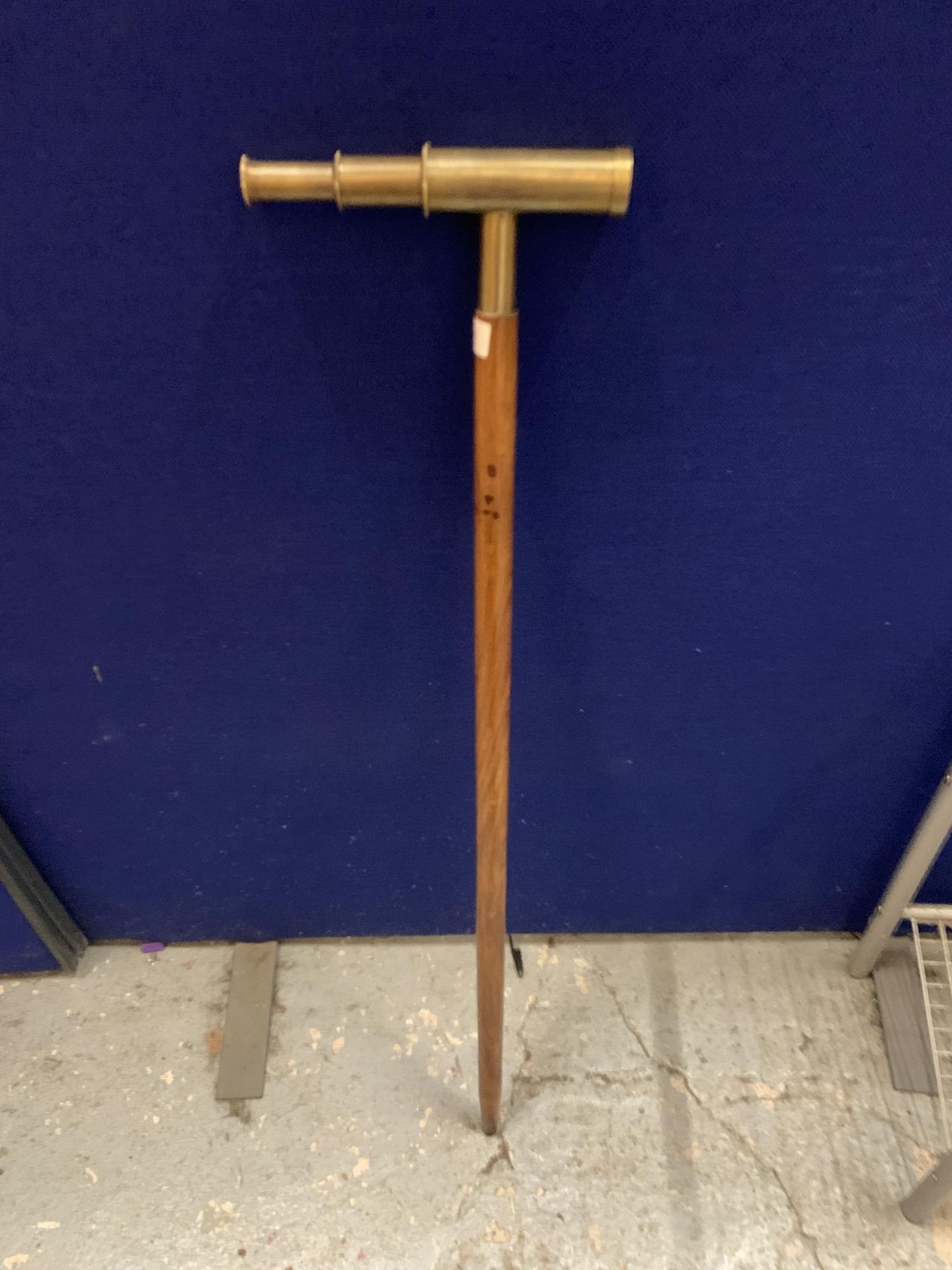 A WALKING STICK WITH A BRASS TELESCOPE HANDLE