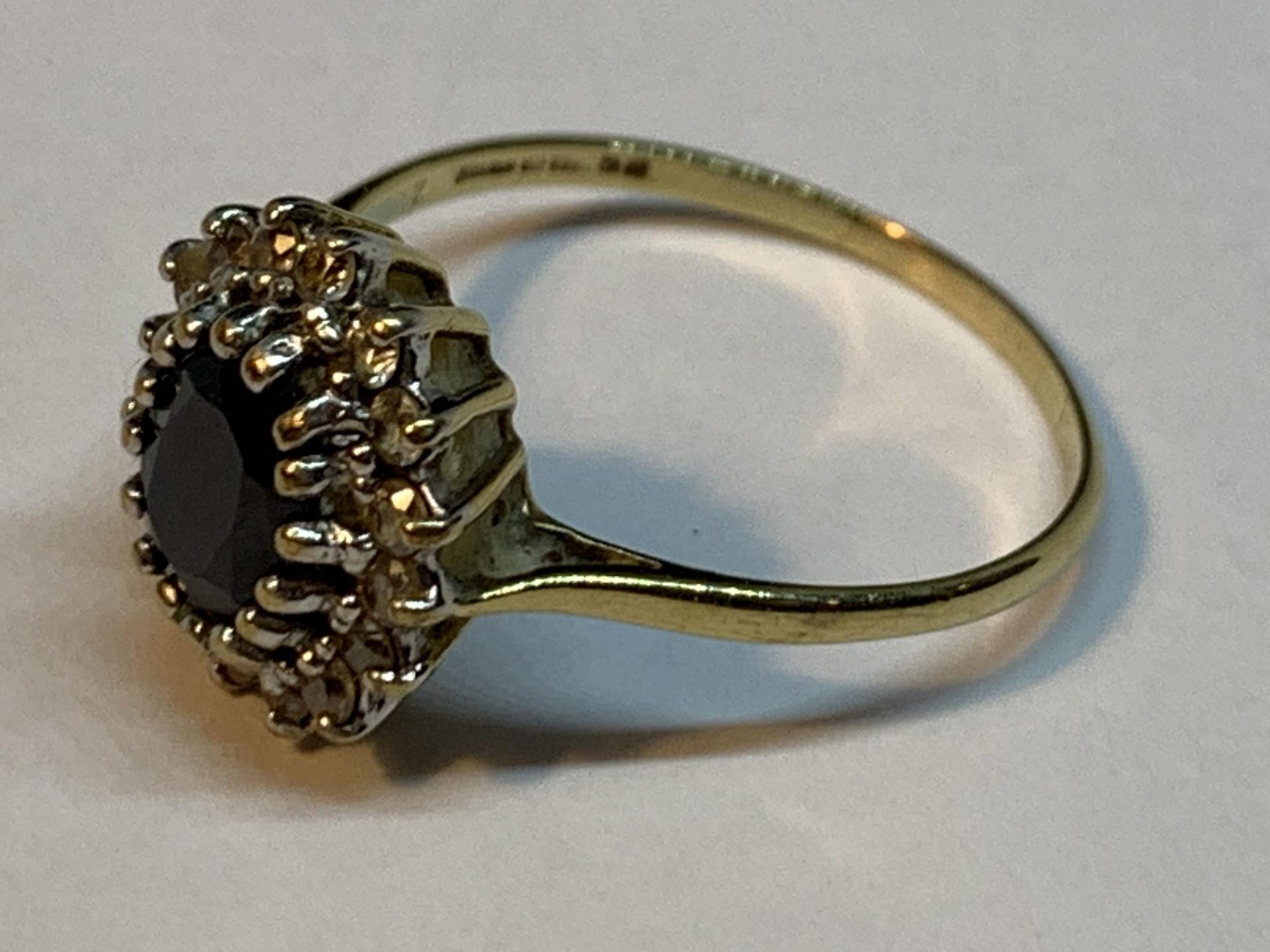 A 9 CARAT GOLD RING WITH A CENTRE SAPPHIRE SURROUNDED BY DIAMONDS SIZE S - Image 2 of 3