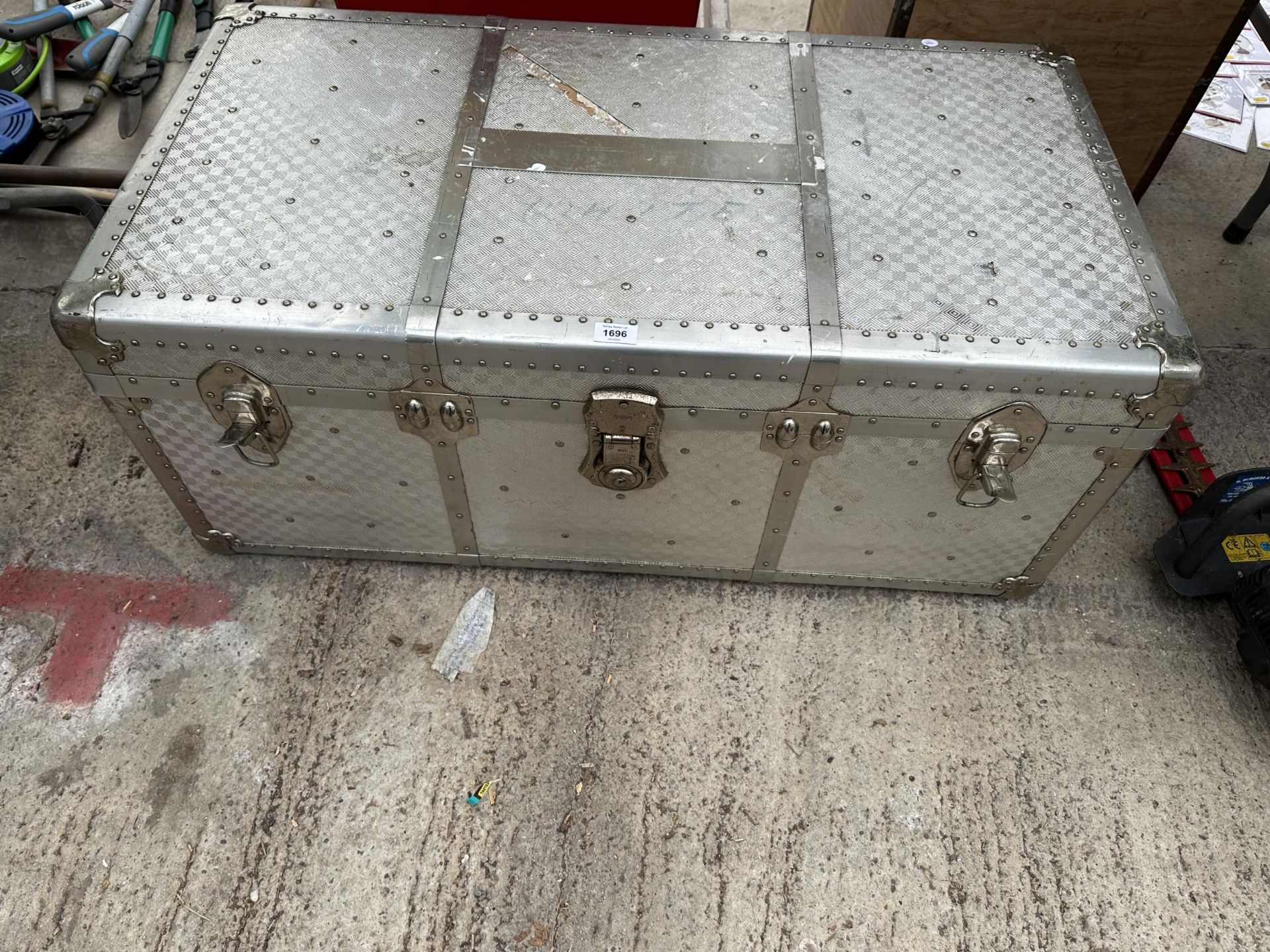 A LARGE ALUMINIUM COVERED TRAVEL TRUNK