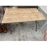 A RUSTIC OAK DINING TABLE ON SHAPED CAST IRON BASE - 54 X 33 INCH