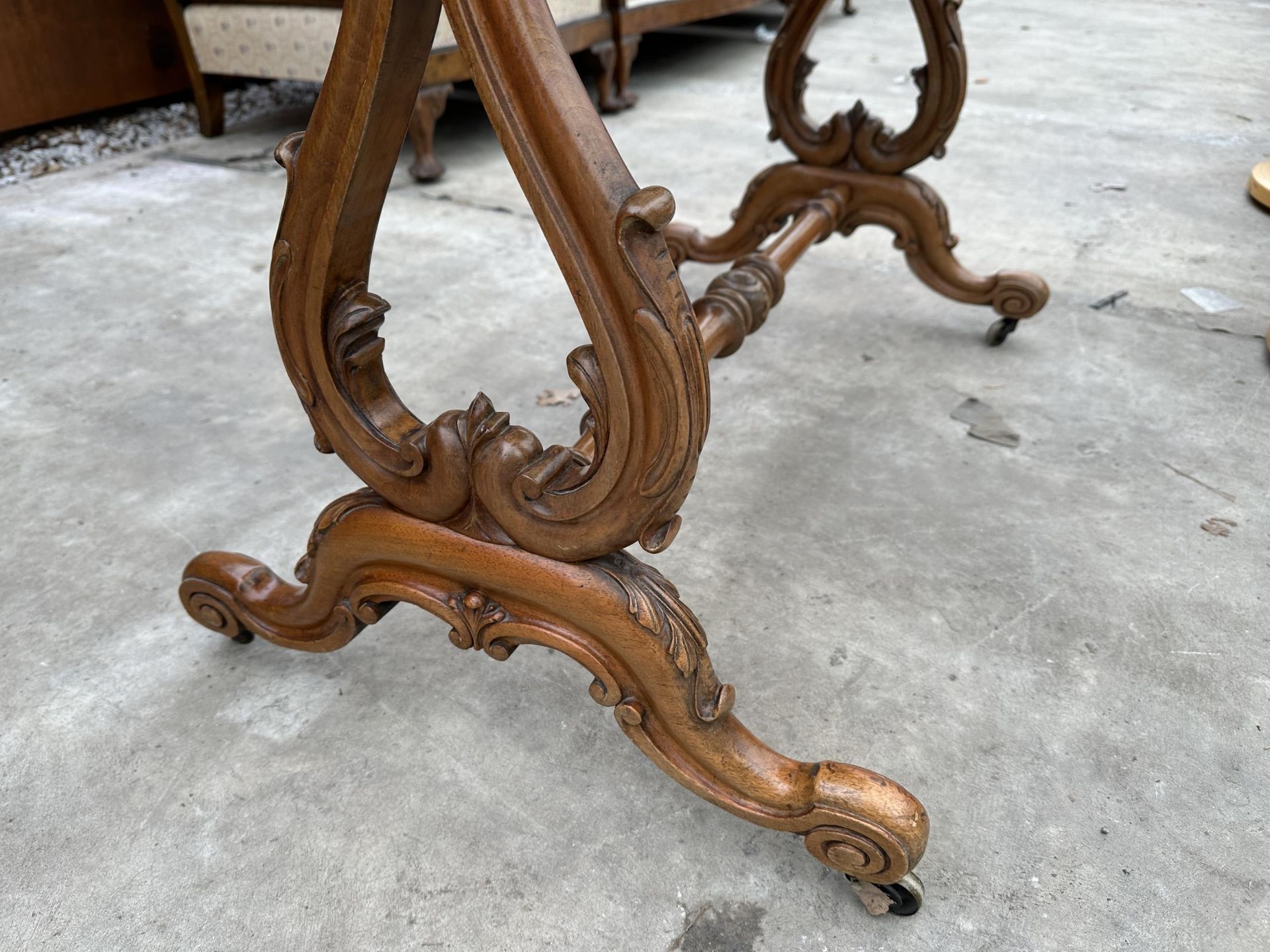 A VICTORIAN WALNUT FOLD OVER GAMES TABLE WITH LYRE SUPPORTS AND TURNED STRETCHER ON BRASS CASTERS - Image 4 of 6