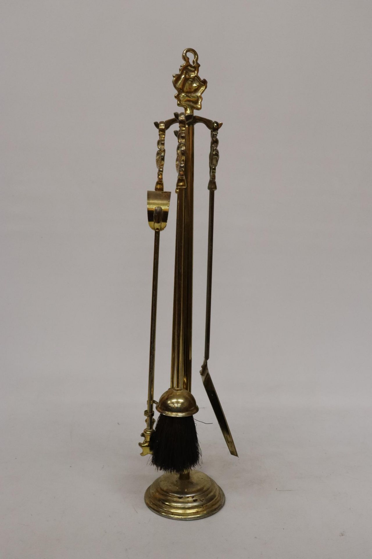 A BRASS COMPANION SET AND STAND WITH GALLEON HANDLES