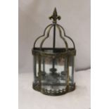 A BRASS AND GLASS TEALIGHT HOLDER WITH A FLEUR DE LYS FINIAL