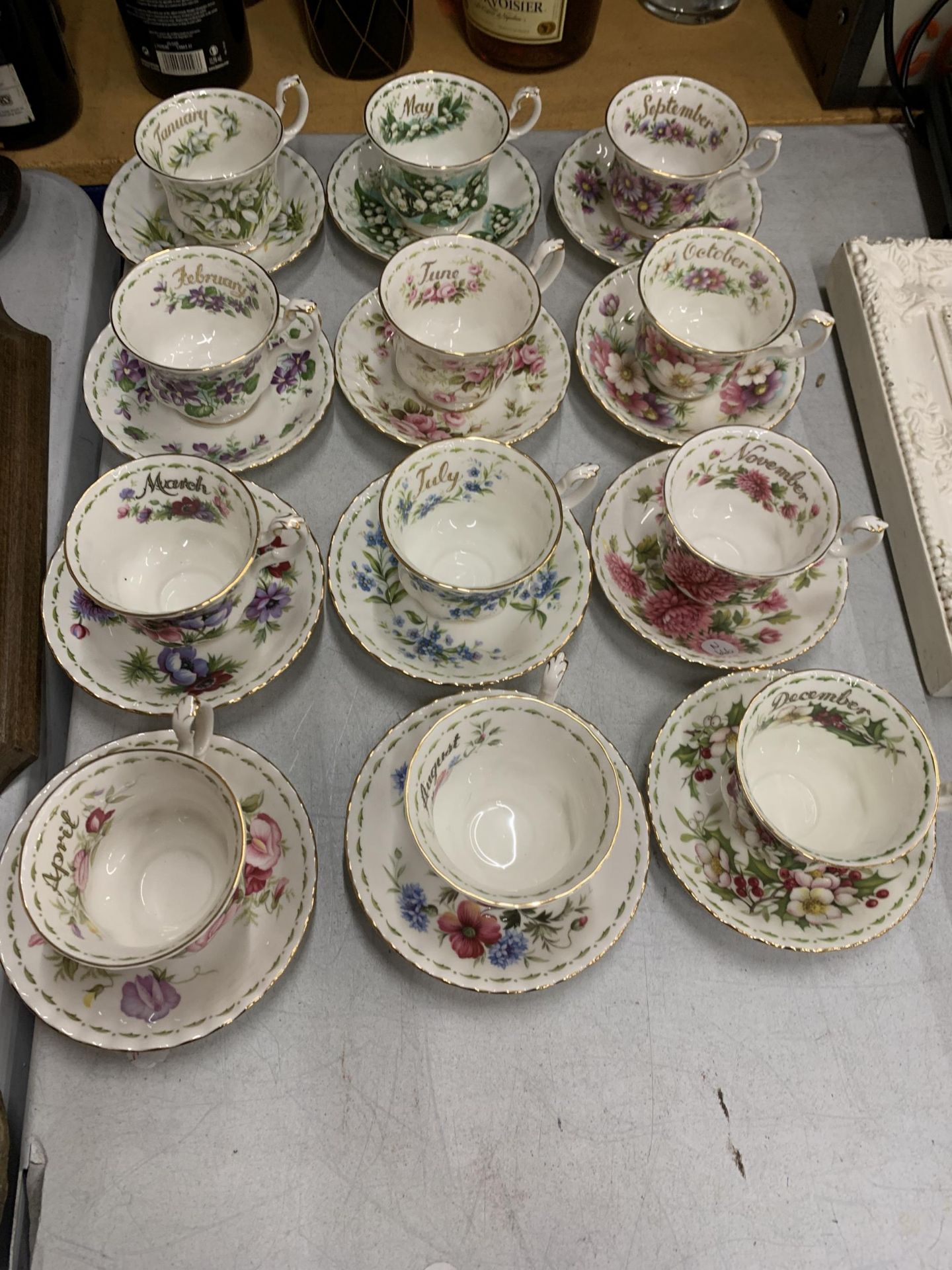 A COMPLETE SET OF ROYAL ALBERT FLOWER OF THE MONTH CUP AND SAUCERS