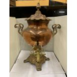 A VINTAGE DECORATIVE COPPER AND BRASS SAMOVAR WITH WHITE HANDLES (ONE A/F)