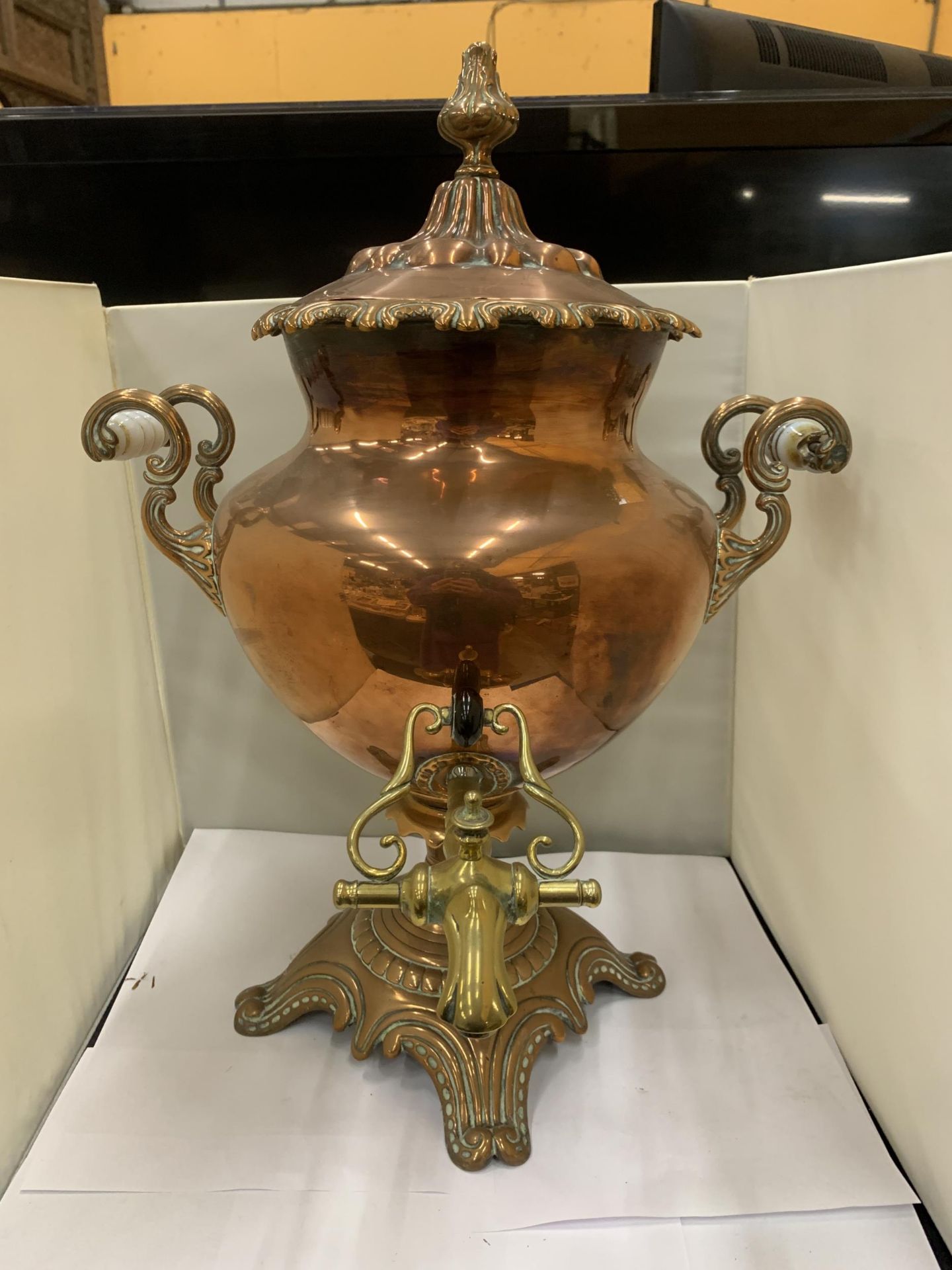 A VINTAGE DECORATIVE COPPER AND BRASS SAMOVAR WITH WHITE HANDLES (ONE A/F)