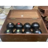 EIGHT CARPET BOWLS IN A WOODEN BOX