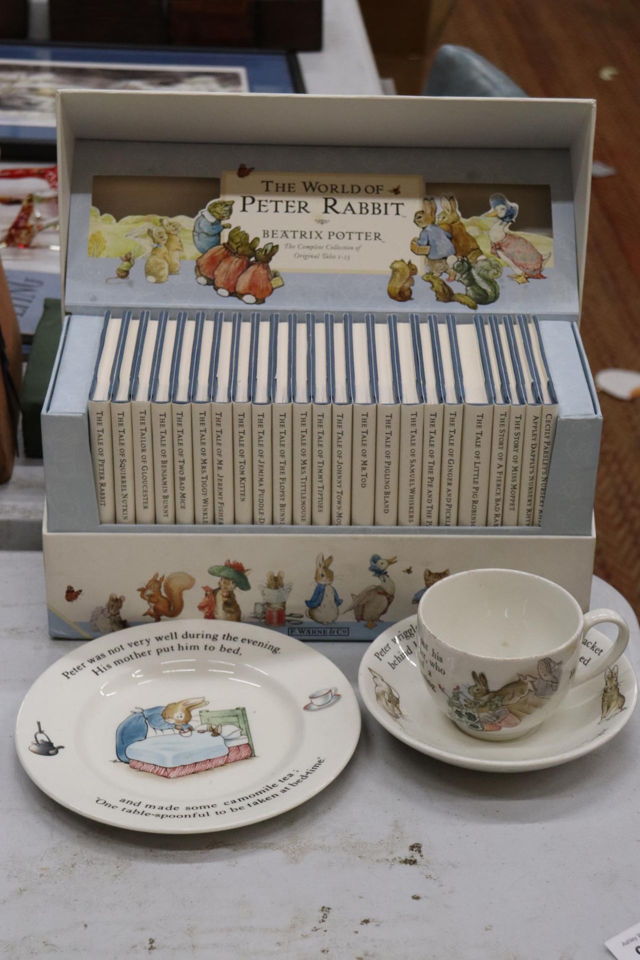 A BOXED 'THE WORLD OF PETER RABBIT' COLLECTION OF BOOKS PLUS THREE PIECES OF WEDGWOOD PETER RABBIT