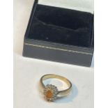 A 9 CARAT GOLD RING WITH CENTRE CITRINE SURROUNDED BY DIAMONDS SIZE O IN A PRESENTATION BOX