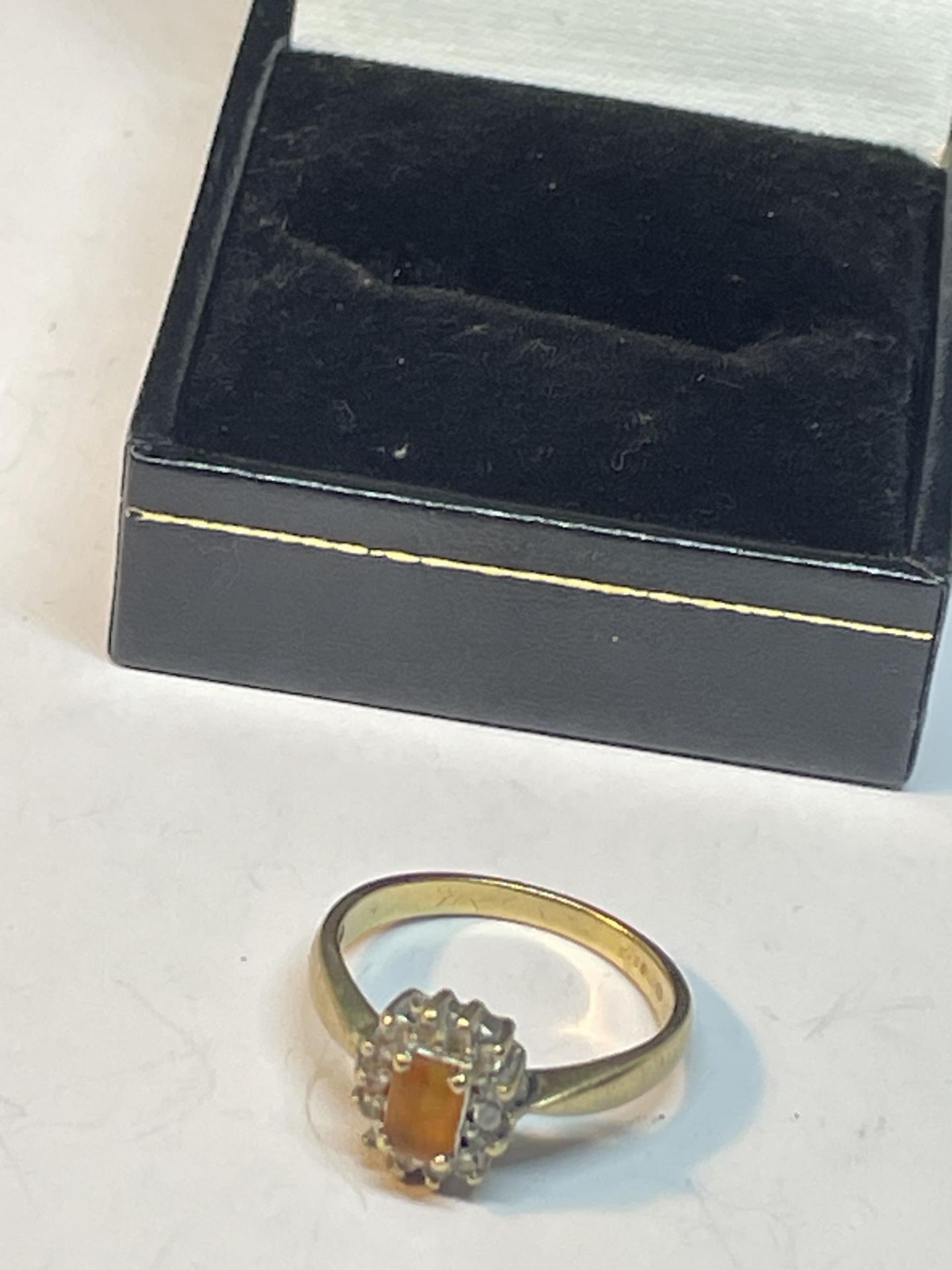 A 9 CARAT GOLD RING WITH CENTRE CITRINE SURROUNDED BY DIAMONDS SIZE O IN A PRESENTATION BOX