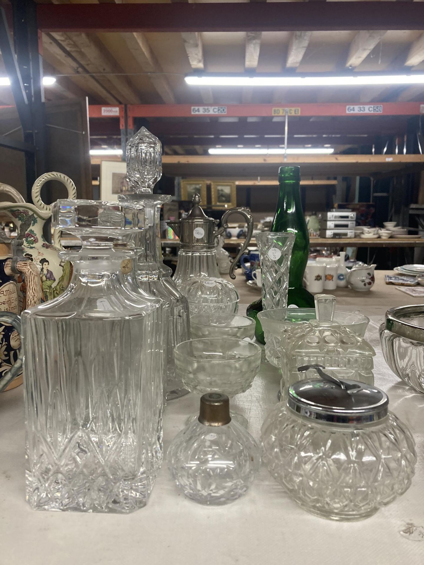 A QUANTITY OF CUT GLASS TO INCLUDE DECANTERS, JARS, SILVER PLATED TOP CARAFE ETC