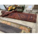 A LARGE VINTAGE RED PATTERNED FRINGED RUG