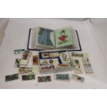 AN ALBUM OF VINTAGE POSTCARDS AND A QUANTITY OF CIGARETTE CARDS