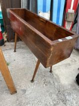 A WOODEN TROUGH PLANTER ON RETRO LEGS