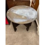 AN INDIAN BRASS TABLE ON A FOLDING HARDWOOD BASE 22.5" DIAMETER