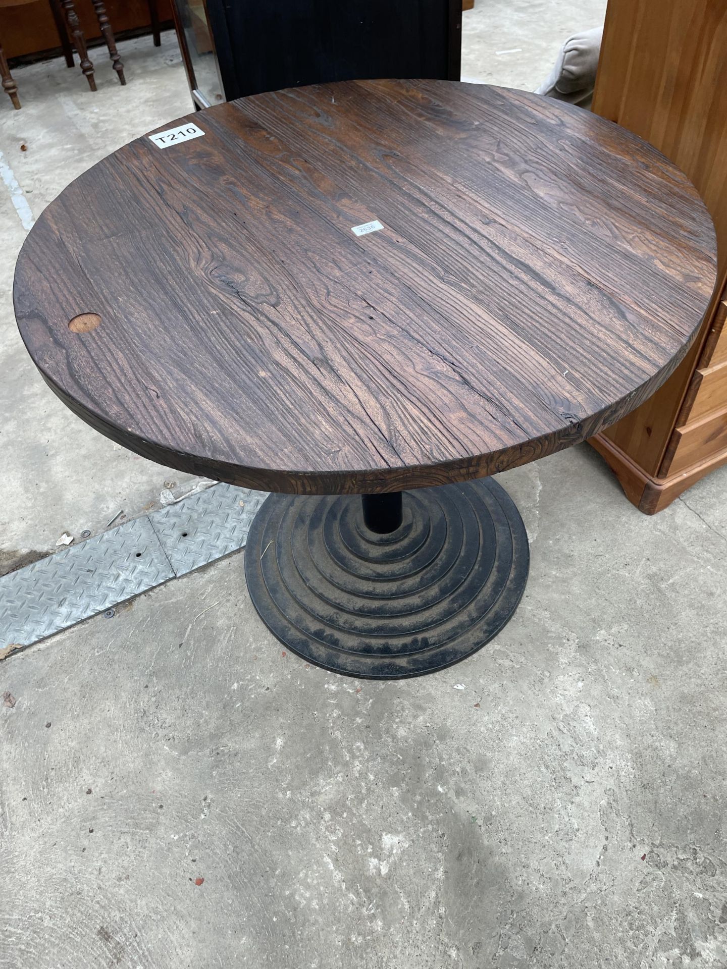 A PUB TABLE ON A STEPPED METALWARE BASE 36" DIAMETER