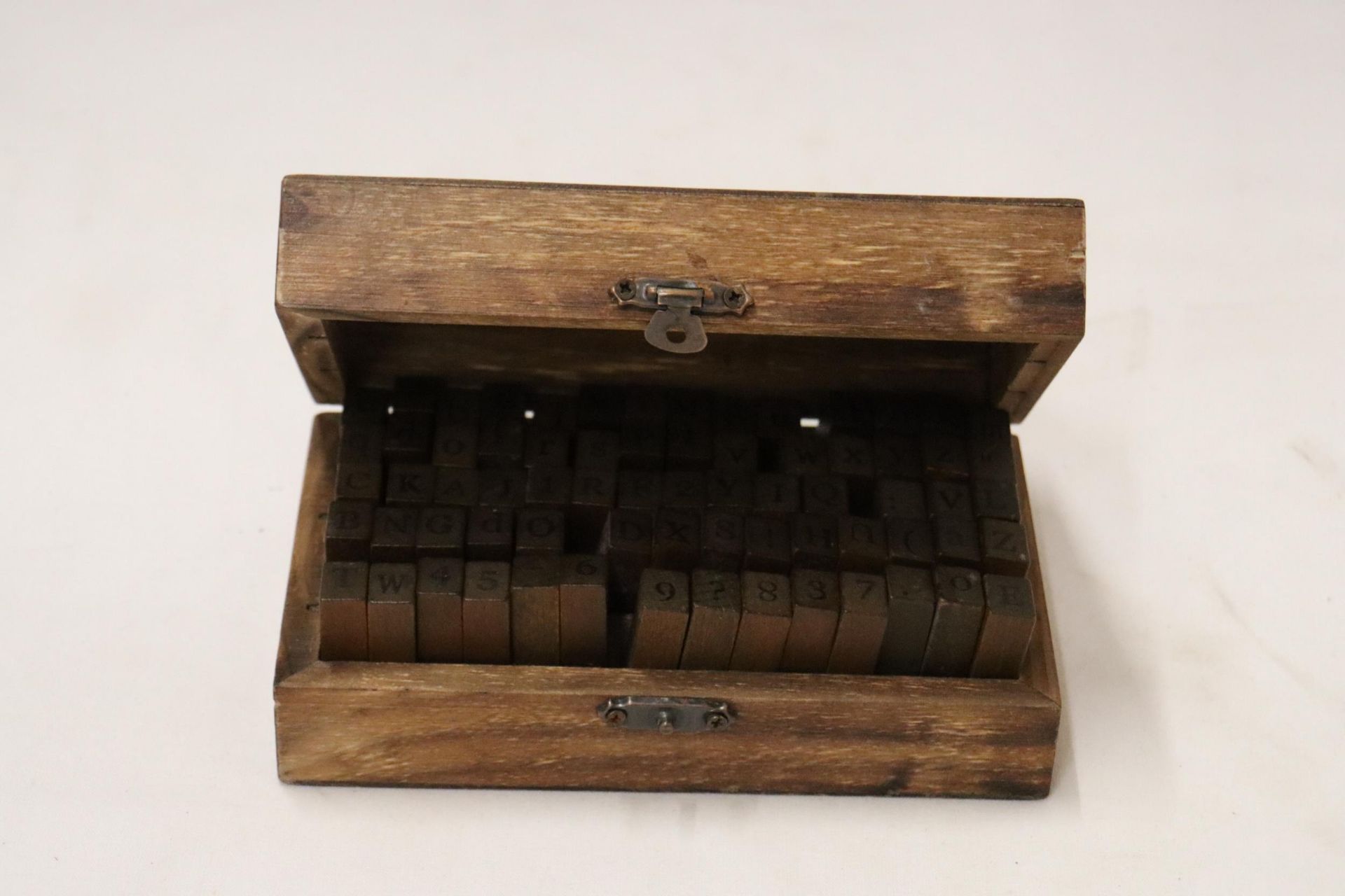 A VINTAGE BOX CONTAINING A QUANTITY OF NUMBER AND LETTER STAMPS