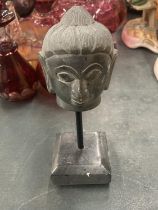 A GREEN STONE (TIBETAN) BUDDAH'S HEAD ON A PLINTH, HEIGHT 17CM