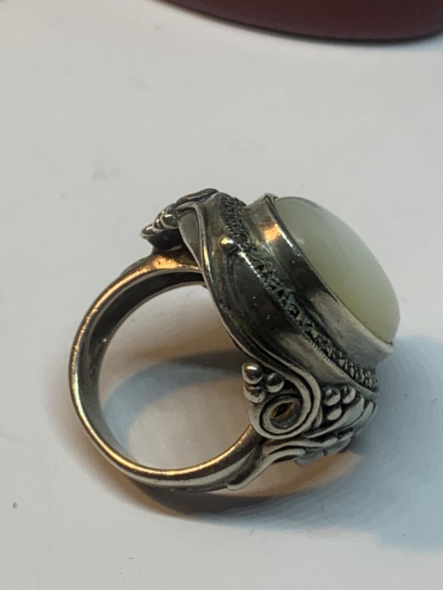 A LARGE SILVER DRESS RING WITH WHITE OPAL COLOURED STONE IN A PRESENTATION BOX - Bild 2 aus 2
