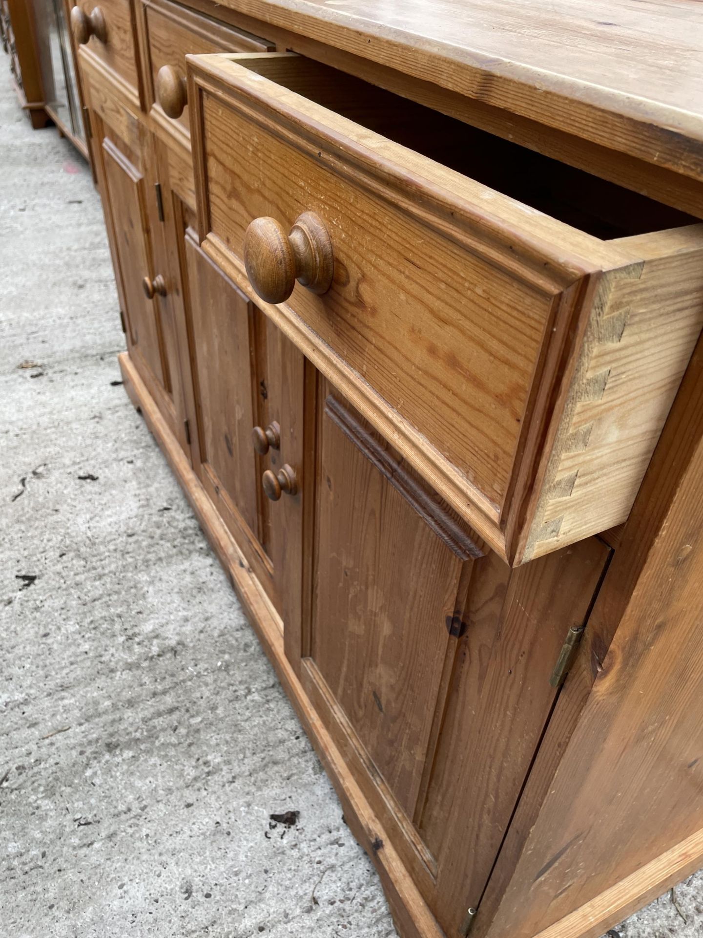 A MODERN PINE DRESSER BASE ENCLOSING DRAWERS AND CUPBOARD - 54 INCH WIDE - Image 3 of 3