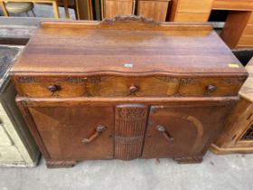 AN EARLY TWENTIETH CENTURY OAK SIDEBOARD ENCLOSING THREE DRAWERS AND TWO CUPBOARDS, 48" WIDE