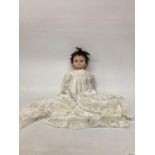 A VINTAGE ROSEBUD COMPOSITION DOLL (BRAND NAME OF NENE PLASTICS) WEARING A PERIOD SATIN