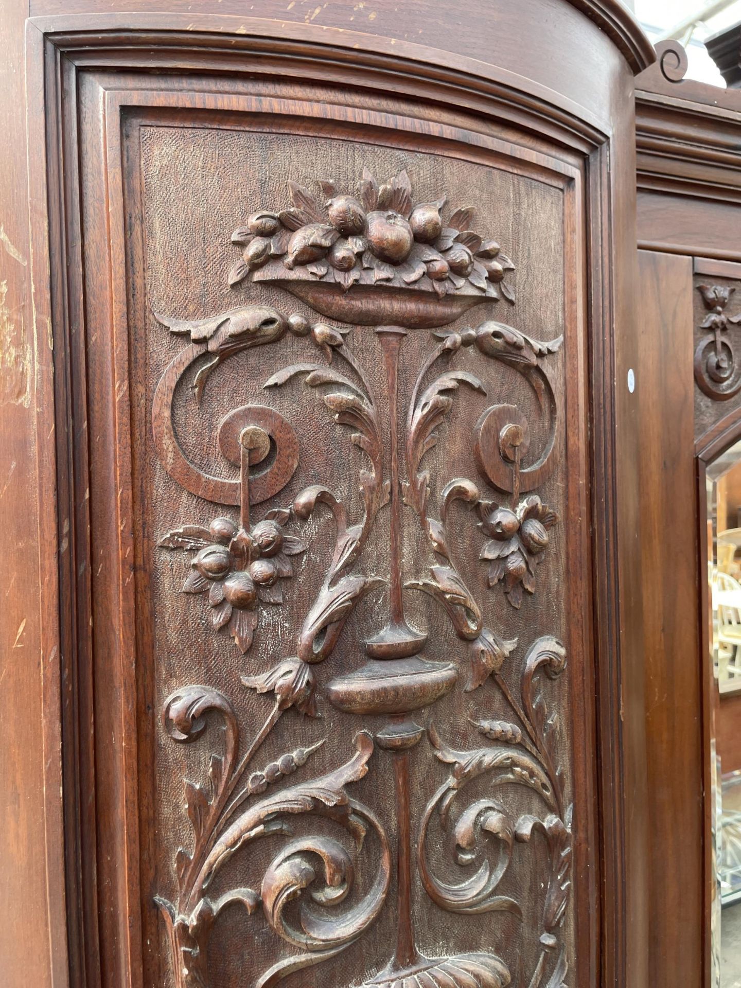 A VICTORIAN MAHOGANY DOUBLE BOW FRONTED MIRROR DOOR WARDROBE WITH FOLIATE CARVED PANELS AND THREE - Image 4 of 10