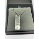 AN ORNATE SILVER INGOT AND CHAIN IN A PRESENTATION BOX
