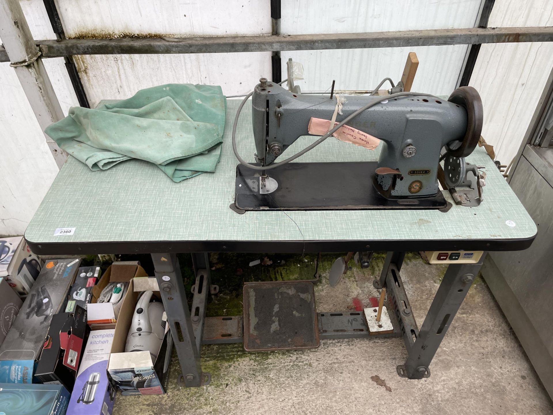 A VINTAGE SINGER INDUSTRIAL SEWING MACHINE WITH TREADLE BASE