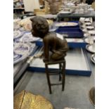 A SIGNED BRONZE CHILD ON A CHILD, HEIGHT 24CM