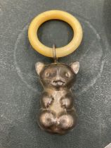 AN EARLY 20TH CENTURY TEETHING RING WITH TEDDY BEAR CHARM