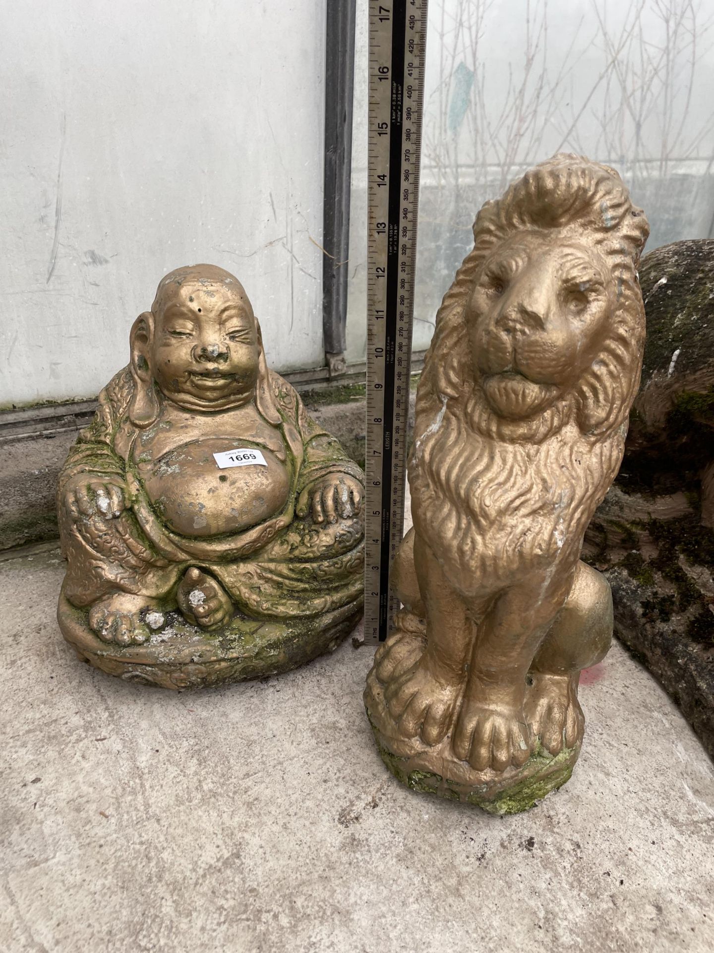 TWO GILT PAINTED CONCRETE GARDEN FIGURES TO INCLUDE A BUDDHA AND A LION