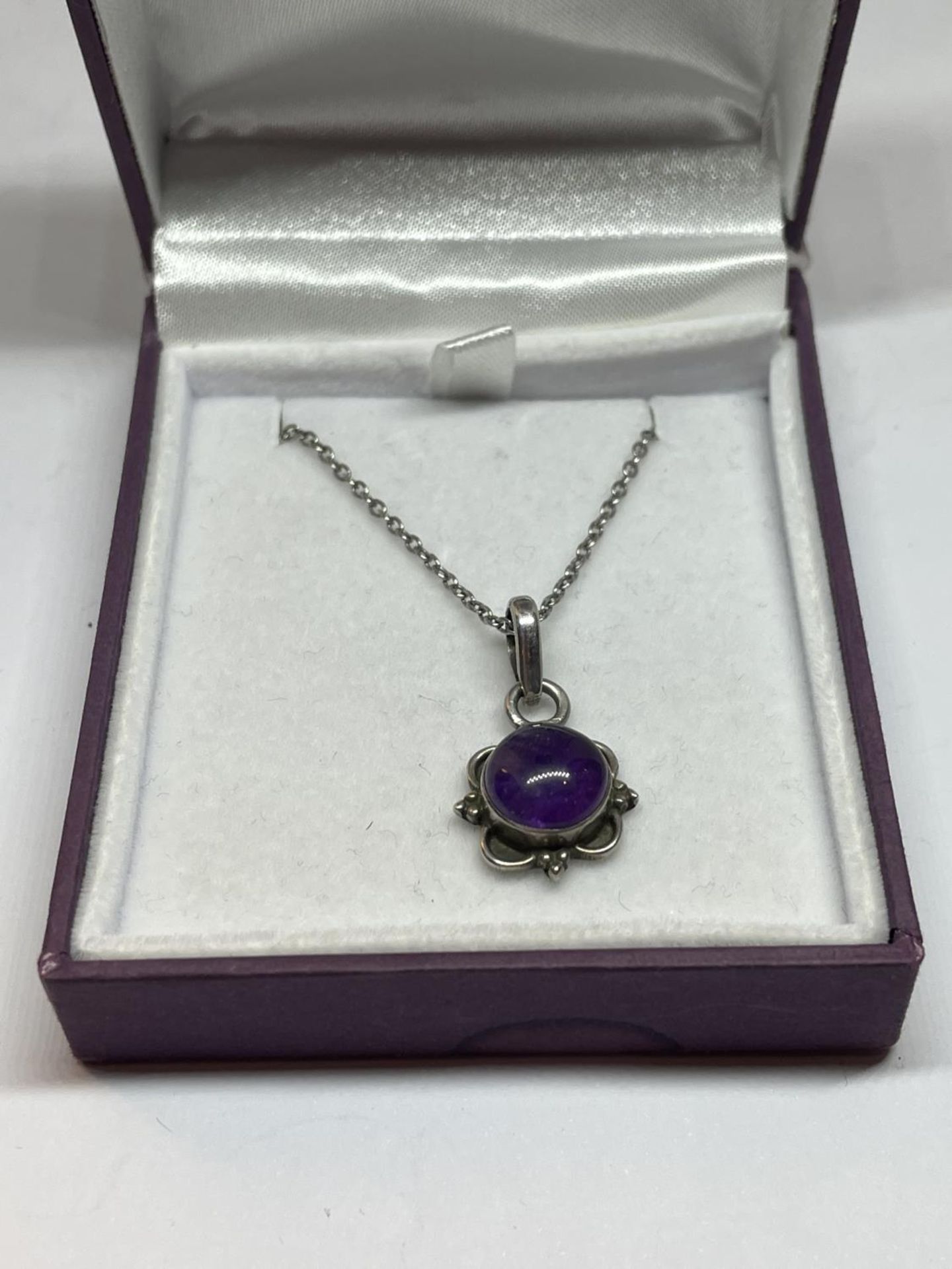 A SILVER AND AMETHYST NECKLACE IN A PRESENTATION BOX