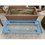 A METAL TROLLEY BASE AND A WOODEN TROUGH PLANTER