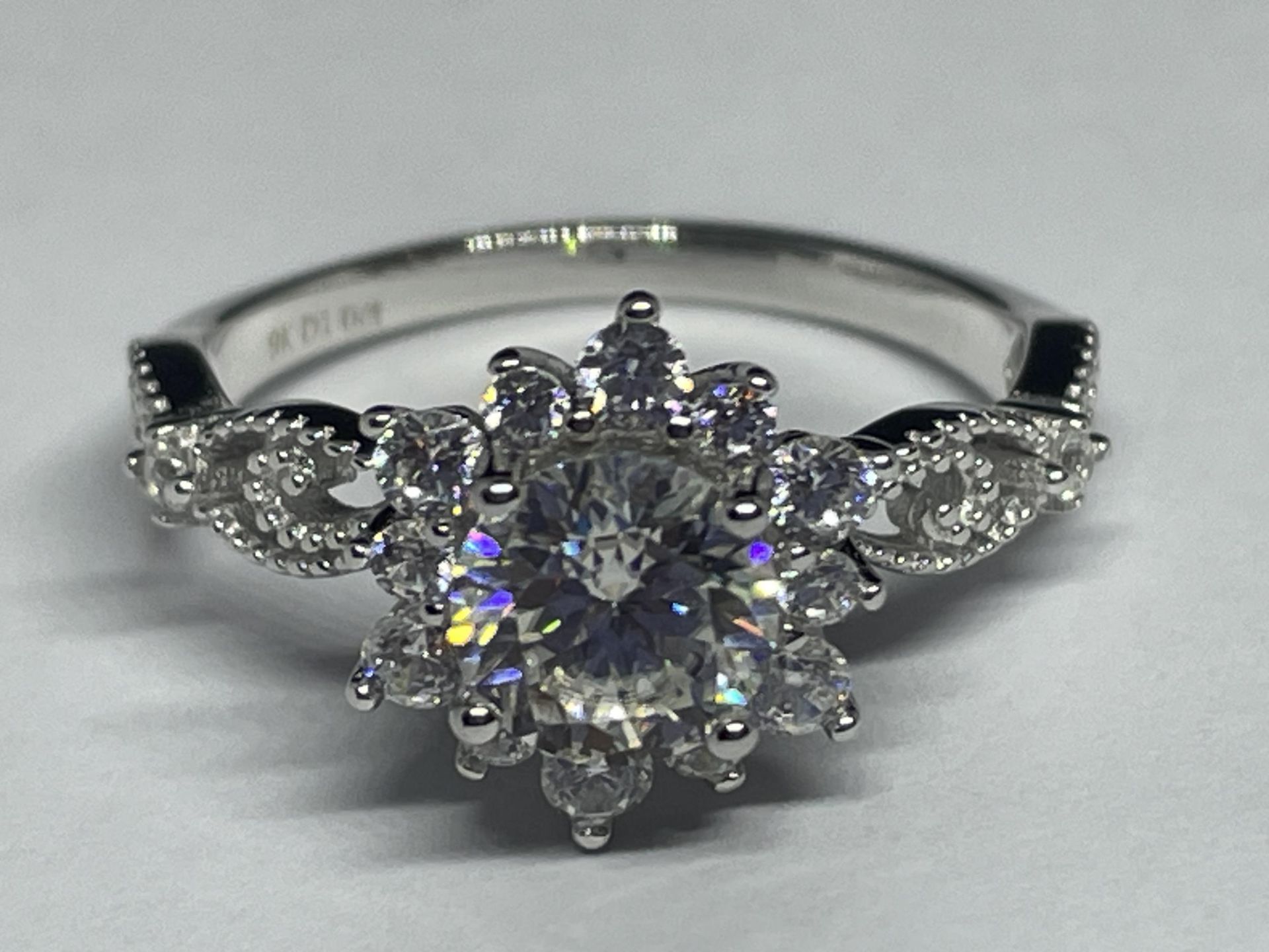 A MARKED 9K RING SET WITH A 1 CARAT OF MOISSANITE AS A FLOWER DESIGN AND CHIPS TO SHOULDERS SIZE P/Q