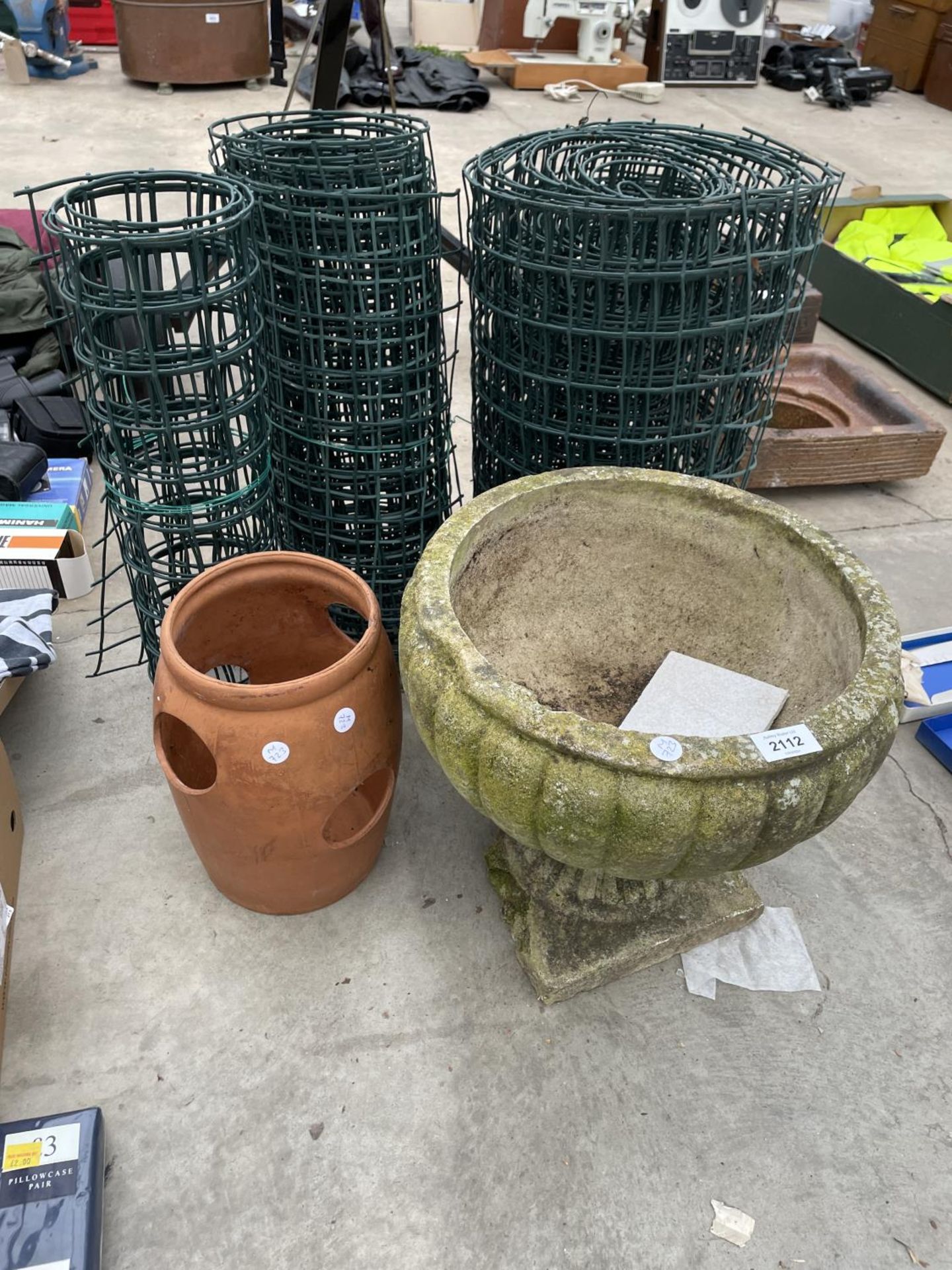 A CONCRETE PLANTER, A TERRACOTTA STRAWBERRY POT AND PLASTIC FENCING