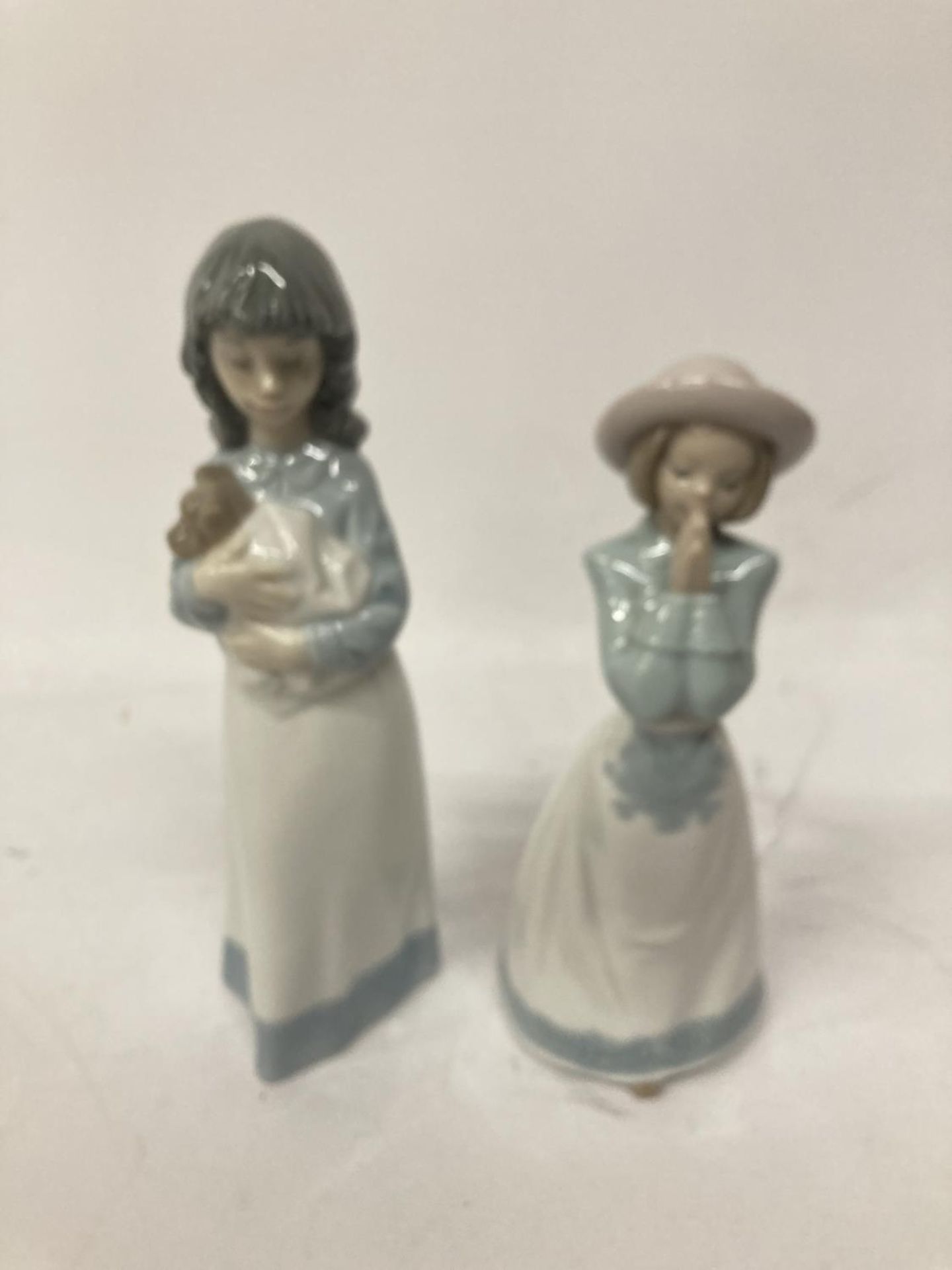 TWO GIRL NAO FIGURINES ONE PRAYING AND ONE HOLDING ADOG
