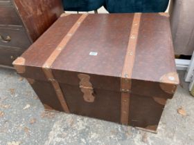 A MODERN TRUNK WITH LEATHER STRAPS