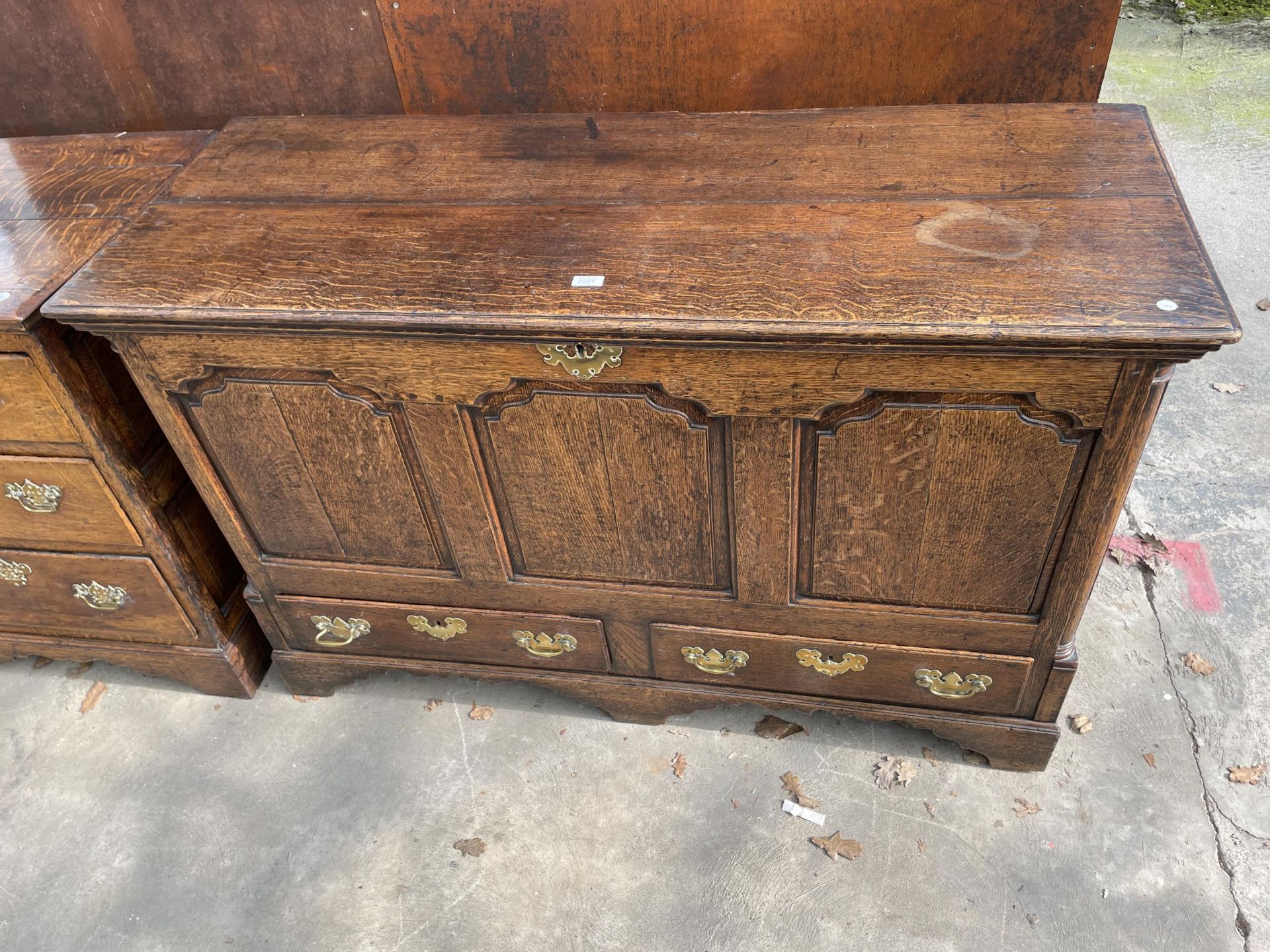 A GEORGE III OAK LANCASHIRE CHEST WITH A THREE PANEL FRONT AND TWO DRAWERS TO BASE ON BRACKET FEET